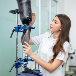 Eine Mechanikerin für Orthopädietechnik überprüft eine Beinprothese