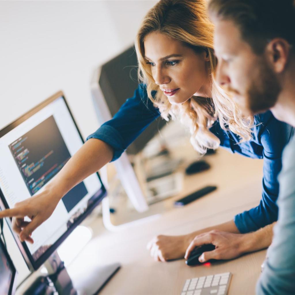 2 Fachinformatiker vor mehreren Bildschirmen 