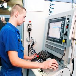 Ein junger Maschinenführer vor seinem Bedienpult